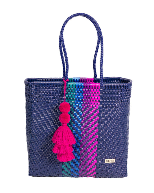 Blue woven tote bag with pink tassels on a white background
